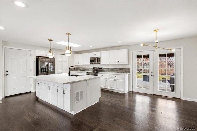 6614 Everett St, Arvada, CO 80004 - kitchen featuring appliances with stainless steel finishes, white cabinets, recessed lighting, light countertops, and dark wood-type flooring