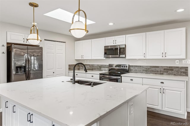 6614 Everett St, Arvada, CO 80004 - kitchen with stainless steel appliances, a skylight, white cabinetry, recessed lighting, and hanging light fixtures