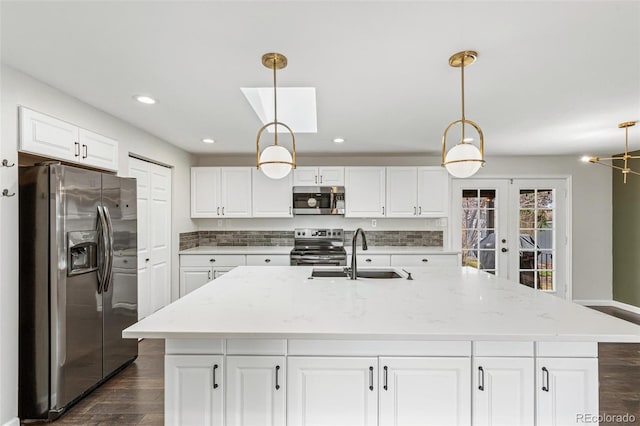 6614 Everett St, Arvada, CO 80004 - kitchen featuring appliances with stainless steel finishes, dark wood-style floors, french doors, white cabinets, and recessed lighting