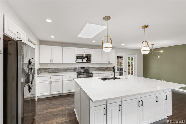 6614 Everett St, Arvada, CO 80004 - kitchen with stainless steel appliances, french doors, a skylight, white cabinets, and recessed lighting