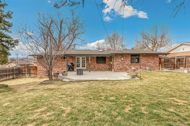 6614 Everett St, Arvada, CO 80004 - back of property featuring french doors, a patio area, a fenced backyard, and brick siding