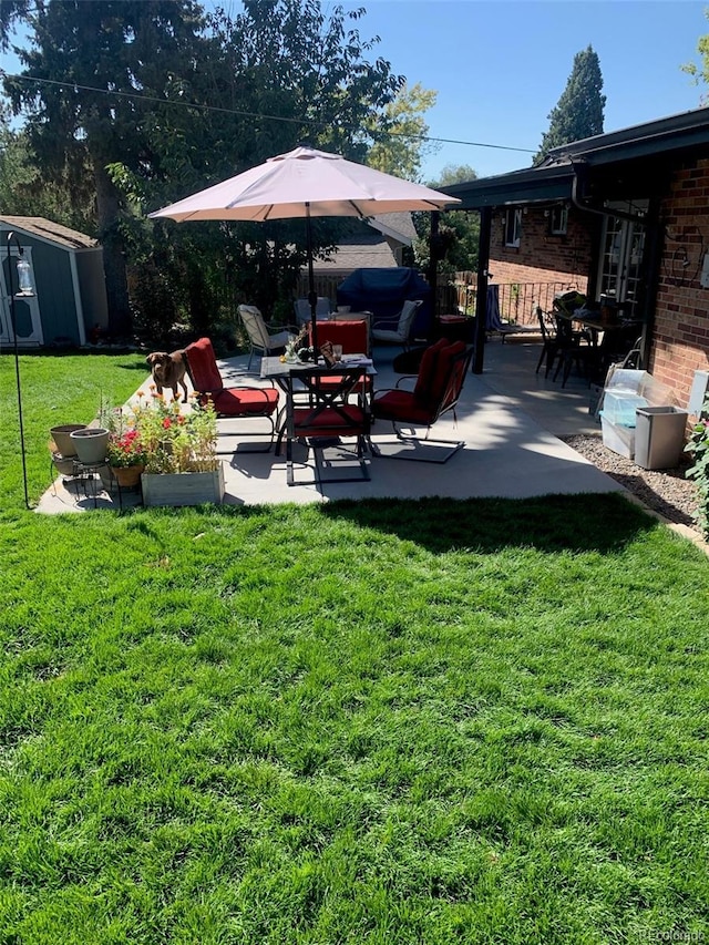 6614 Everett St, Arvada, CO 80004 - view of grassy yard featuring a patio and a storage unit
