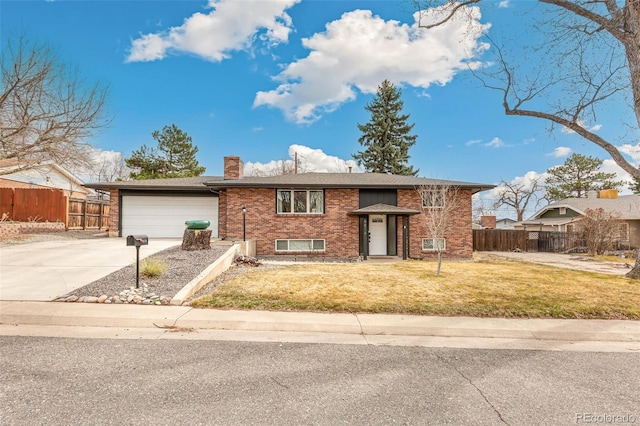 6614 Everett St, Arvada, CO 80004 - bi-level home featuring brick siding, a chimney, concrete driveway, and a garage