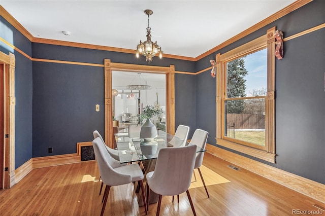 dining space with visible vents, a notable chandelier, baseboards, and wood finished floors