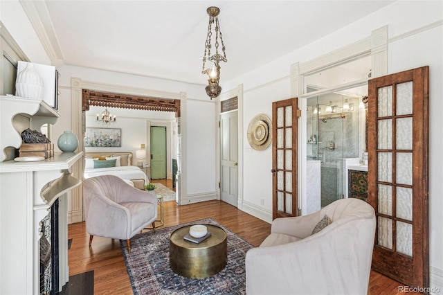 sitting room featuring french doors, baseboards, and wood finished floors