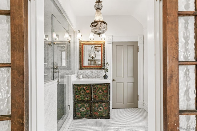 bathroom with vaulted ceiling, a stall shower, backsplash, and vanity