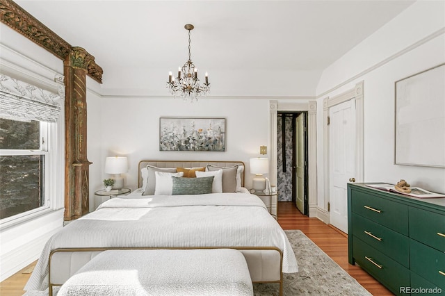 bedroom with an inviting chandelier and wood finished floors