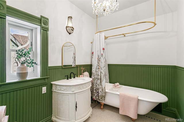 bathroom featuring curtained shower, a wainscoted wall, vanity, a freestanding bath, and an inviting chandelier