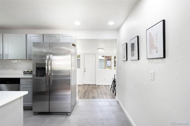 1180 Newark St, Aurora, CO 80010 - kitchen with stainless steel appliances, light countertops, gray cabinets, decorative backsplash, and baseboards