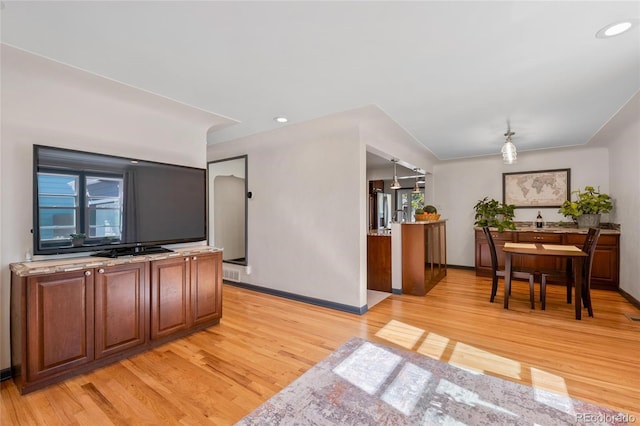 kitchen featuring light wood-type flooring, stainless steel fridge with ice dispenser, baseboards, and recessed lighting