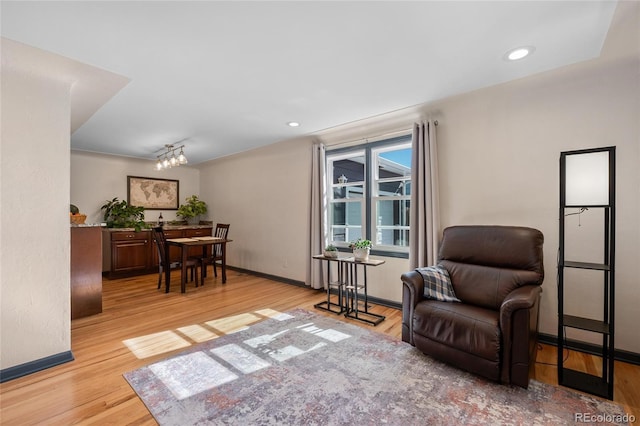 living area with baseboards, wood finished floors, and recessed lighting