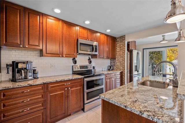 kitchen with light tile patterned floors, light stone counters, stainless steel appliances, a sink, and decorative backsplash