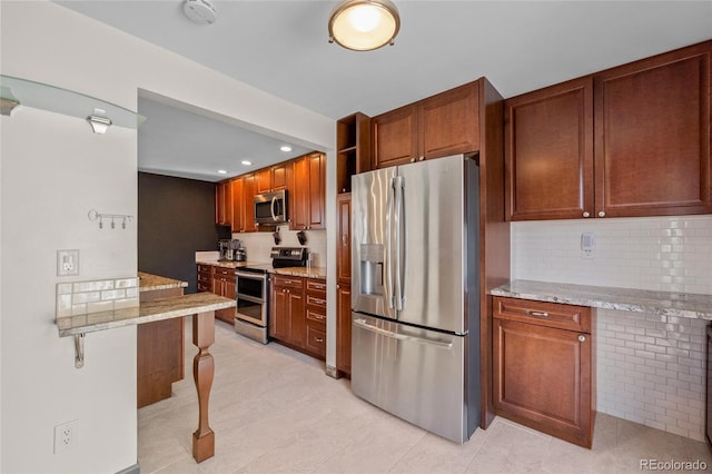 kitchen with appliances with stainless steel finishes, tasteful backsplash, brown cabinetry, and light stone countertops