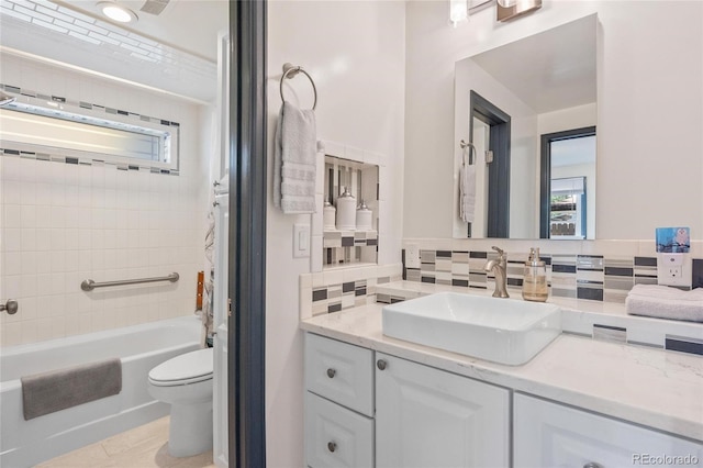 bathroom featuring tasteful backsplash, tub / shower combination, vanity, and toilet