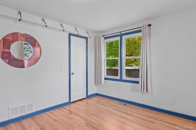 empty room with visible vents, baseboards, and wood finished floors