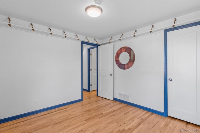 spare room featuring light wood-style floors, baseboards, and visible vents