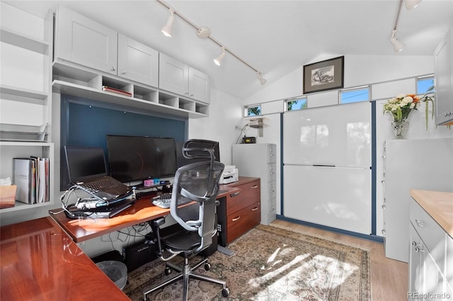 office with vaulted ceiling, track lighting, and wood finished floors