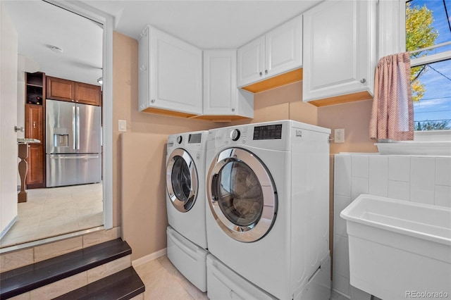 laundry room with cabinet space, independent washer and dryer, a sink, and light tile patterned flooring