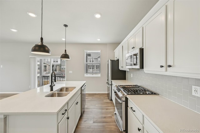 6225 N Nepal Ct, Aurora, CO 80019 - kitchen featuring stainless steel appliances, a sink, tasteful backsplash, wood finished floors, and white cabinets