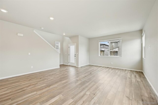 6225 N Nepal Ct, Aurora, CO 80019 - unfurnished living room featuring healthy amount of natural light, light wood-type flooring, recessed lighting, and baseboards