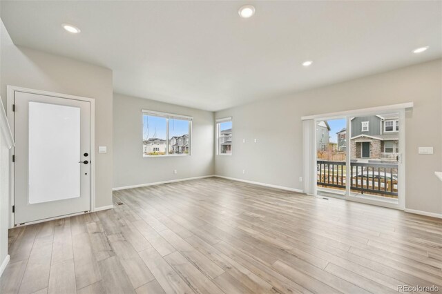 6225 N Nepal Ct, Aurora, CO 80019 - unfurnished living room featuring light wood-style flooring, baseboards, and recessed lighting