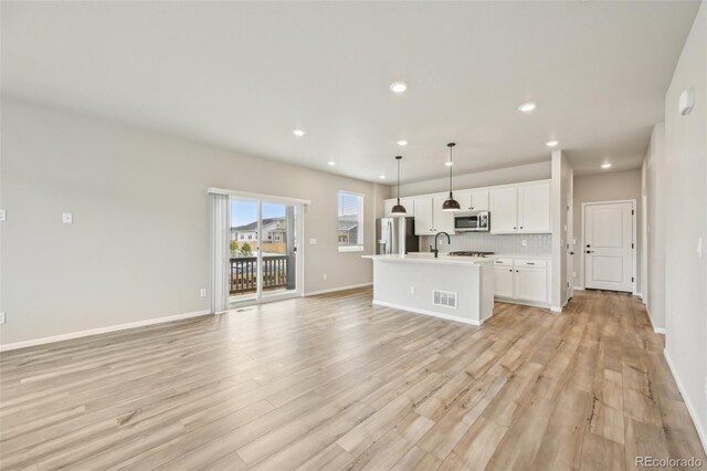 6225 N Nepal Ct, Aurora, CO 80019 - unfurnished living room with recessed lighting, light wood-style flooring, a sink, and baseboards
