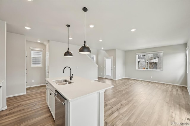 6225 N Nepal Ct, Aurora, CO 80019 - kitchen with a sink, dishwasher, light countertops, light wood-type flooring, and baseboards