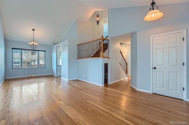 20521 E Bellewood Pl, Aurora, CO 80015 - unfurnished living room with a chandelier, stairway, high vaulted ceiling, wood finished floors, and baseboards