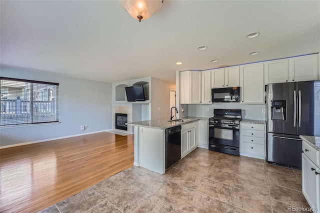 20521 E Bellewood Pl, Aurora, CO 80015 - kitchen with black appliances, a sink, a peninsula, white cabinets, and open floor plan