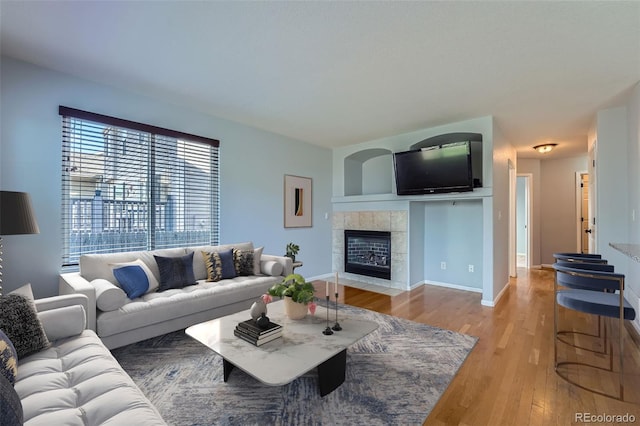 20521 E Bellewood Pl, Aurora, CO 80015 - living area with light wood-style floors, a tiled fireplace, and baseboards
