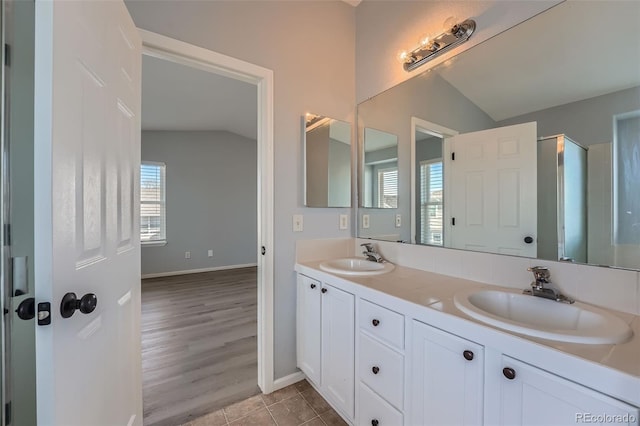 20521 E Bellewood Pl, Aurora, CO 80015 - full bathroom featuring vaulted ceiling, double vanity, tile patterned flooring, and baseboards