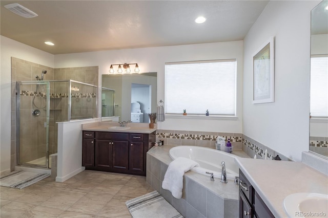 bathroom with vanity and separate shower and tub