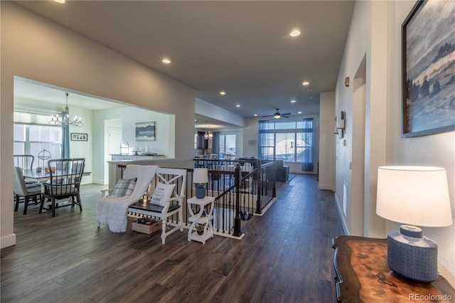 hall featuring dark wood-style flooring, recessed lighting, an inviting chandelier, an upstairs landing, and baseboards