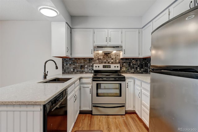 9188 W Ontario Dr, Littleton, CO 80128 - kitchen with stainless steel appliances, a sink, under cabinet range hood, light wood finished floors, and backsplash