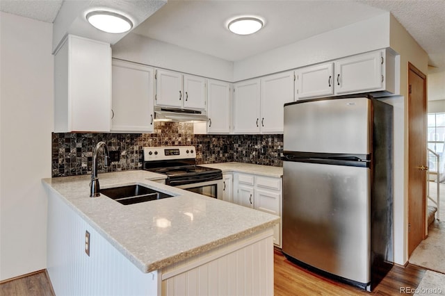 9188 W Ontario Dr, Littleton, CO 80128 - kitchen featuring appliances with stainless steel finishes, under cabinet range hood, a sink, a peninsula, and light wood-style floors