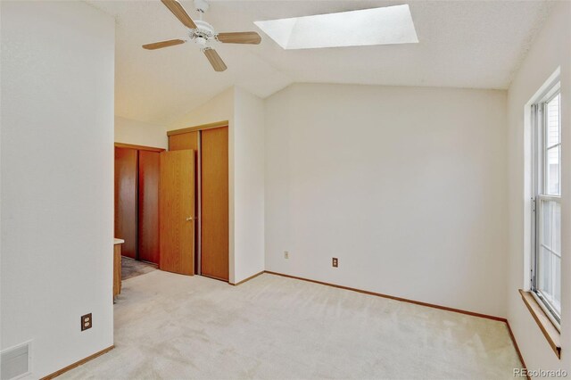 9188 W Ontario Dr, Littleton, CO 80128 - unfurnished bedroom featuring a skylight, light carpet, lofted ceiling, baseboards, and ceiling fan