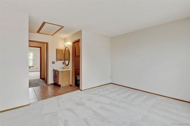 9188 W Ontario Dr, Littleton, CO 80128 - spare room with light carpet, a sink, light tile patterned floors, baseboards, and a textured ceiling
