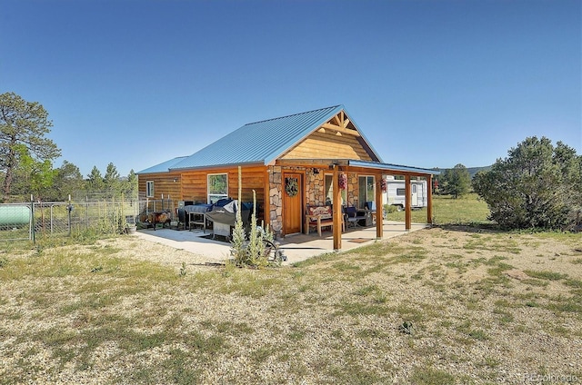 1106 Hull Ave, Westcliffe, CO 81252 - rear view of property with a patio, stone siding, and metal roof