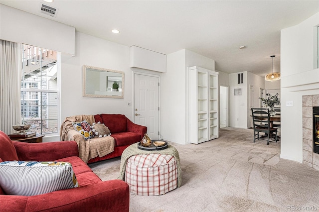 living room with light colored carpet and a tile fireplace