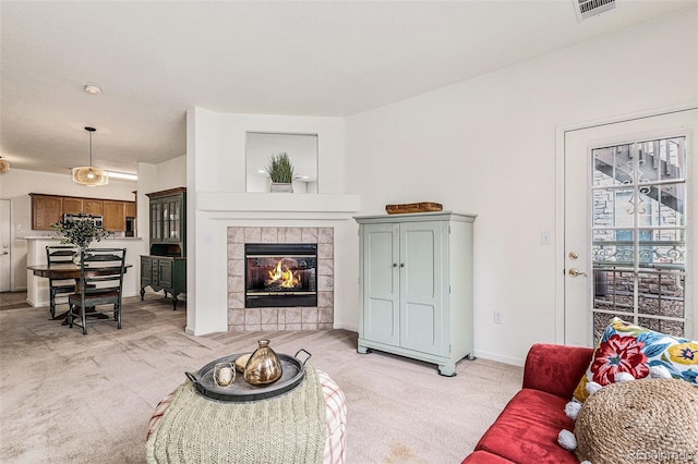 living room featuring light colored carpet and a fireplace