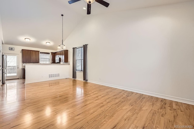 unfurnished living room featuring high vaulted ceiling, light wood-style flooring, visible vents, and a ceiling fan