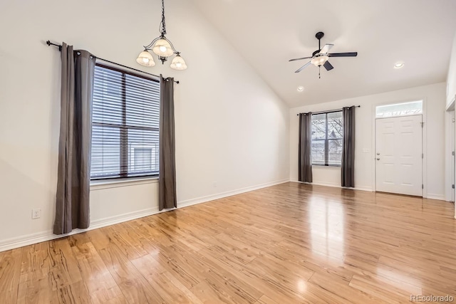 interior space with vaulted ceiling, ceiling fan, baseboards, and light wood-style floors