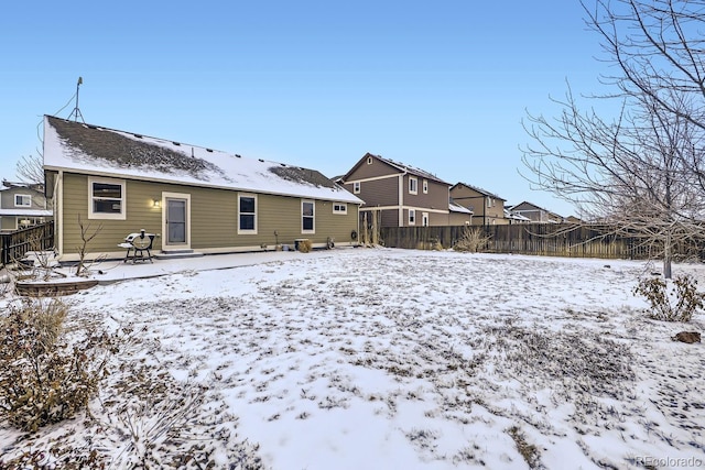 snow covered back of property featuring fence