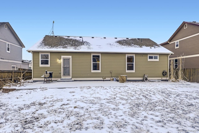 snow covered back of property with entry steps and fence