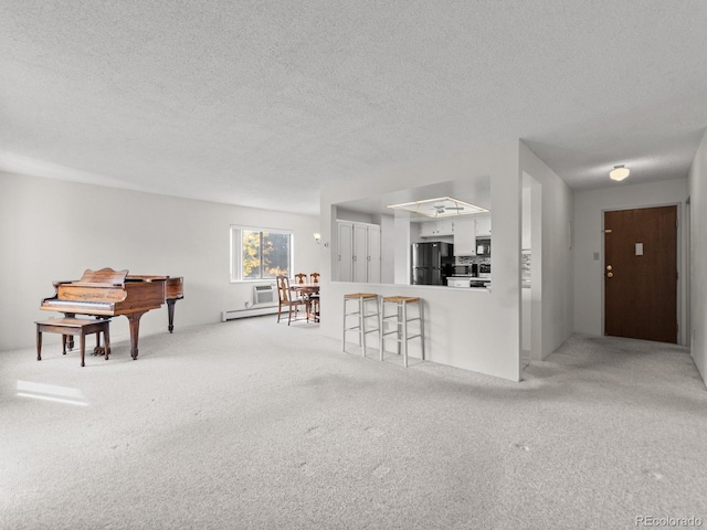 unfurnished living room featuring light carpet, a textured ceiling, and a baseboard heating unit