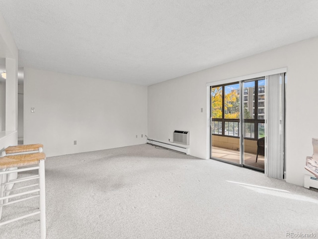 unfurnished living room featuring a textured ceiling, carpet flooring, a baseboard heating unit, and a wall unit AC