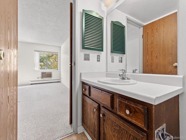 bathroom with vanity, a textured ceiling, a wall mounted air conditioner, and a baseboard heating unit