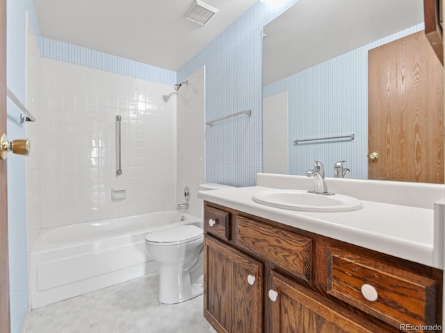 full bathroom featuring vanity, tiled shower / bath combo, and toilet