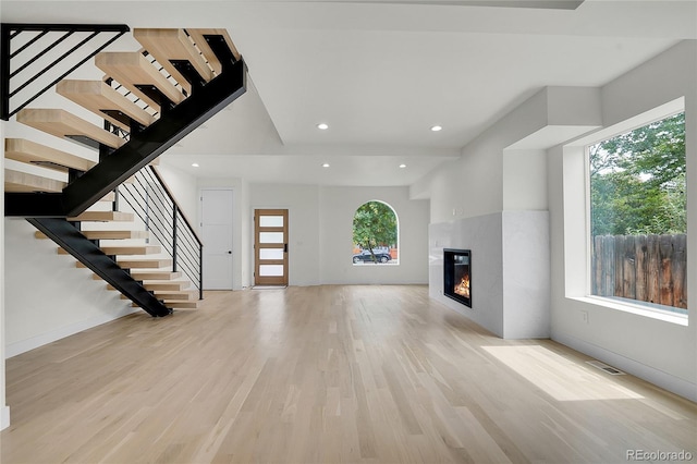 671 Elati St, Denver, CO 80204 - unfurnished living room featuring wood finished floors, stairway, a glass covered fireplace, recessed lighting, and baseboards