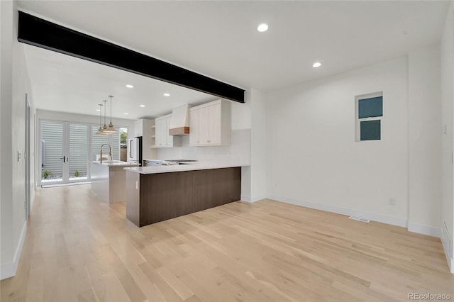 671 Elati St, Denver, CO 80204 - kitchen with light countertops, light wood-style floors, white cabinetry, baseboards, and recessed lighting